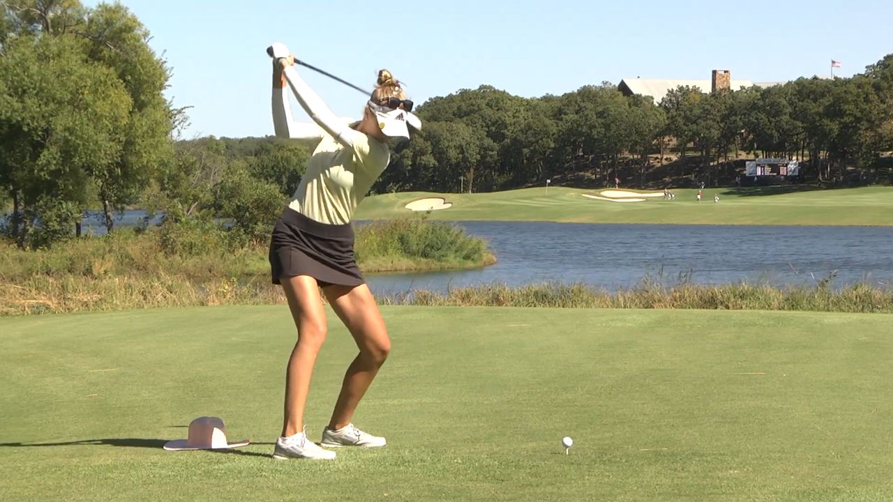 Nelly Korda swinging at a golf course